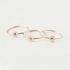 One gold letter ring. Personalize a gift she'll treasure with our gold initial ring. An adorably petite initial, imprinted on a 14k gold filled disk - paired with a super skinny (1mm) gold filled band - creates the perfect stacking ring, customized with your monogram. Lovely as a stand alone. Also sits beautifully with multiple initials stacked or our hammered gold stacking ring bands. This gold initial ring arrives custom made to order in your size hand stamped with the letter of your choice. A