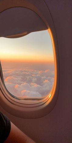 an airplane window looking out at the clouds