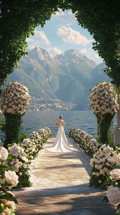 a woman in a wedding dress is standing on a walkway with flowers and greenery