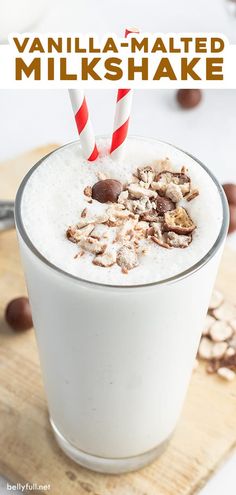 a glass filled with milk and nuts on top of a cutting board