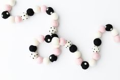 two black and white beads are arranged in the shape of the word love on a white surface