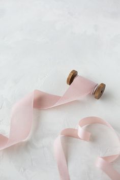 a roll of pink ribbon with two wooden spools