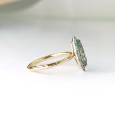 a close up of a ring with an oval shaped green stone on it's side