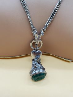 In good used vintage condition.  The silver tone chain is slightly twisted because that's the way it was made. Unknown maker.  Very unique looking.  Silver tone metal with dangling small lockets that actually open and a fob with a green end. Please look at the pictures for details and condition because the exact item pictured is the exact item that you will receive. Vintage Silver Dangle Charm Necklaces, Vintage Sterling Silver Charm Necklace With Lobster Clasp, Vintage Silver Charm Necklace With Locket, Vintage Silver Locket Charm Necklaces, Vintage Silver Locket Charm Necklace, Vintage Metal Locket Charm Necklaces, Vintage Metal Locket Charm Necklace, Vintage Silver Engraved Chain Necklace, Vintage Sterling Silver Chain Necklace With Lobster Clasp