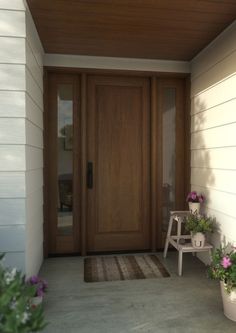 a front door with two planters on the side and a bench in front of it