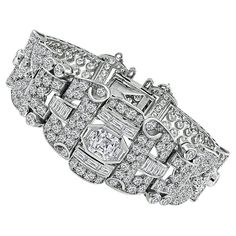 This is a stunning platinum bracelet. The bracelet is centered with a sparkling asscher cut diamond that weighs approximately 1.70ct. The color of the diamond is I with SI1 clarity. The center diamond is accentuated by dazzling baguette, trapezoid, old mine and round cut diamonds that weigh approximately 10.50ct. The color of these diamonds is G-H with VS clarity. The total weight of the diamonds is approximately 12.20ct. The bracelet measures 7 inches in length and 22mm in width at the widest base. The bracelet weighs 46.9 grams. Inventory #75300PAPKS Platinum Bracelet, Asscher Cut Diamond, Modern Bracelets, Gold Armband, Asscher Cut, Round Cut Diamond, Round Cut, Platinum, Jewelry Bracelets