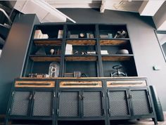 a large black cabinet with wooden shelves and drawers