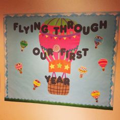 a bulletin board with hot air balloons and the words flying through our first year on it