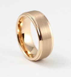 a gold wedding ring on a white background