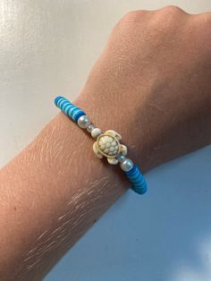 a woman's arm with a blue and white beaded bracelet on top of it