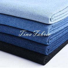 four folded blue and black cloths stacked on top of each other with the word tind fabric written across them