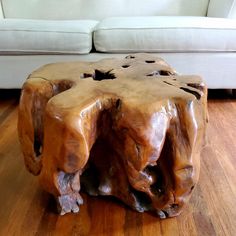 a wooden table sitting on top of a hard wood floor next to a white couch