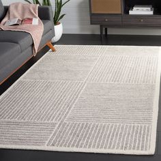 a living room with a gray couch and white rug