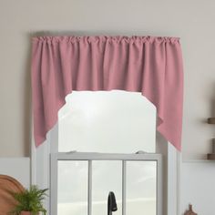 a kitchen window with a pink curtain and potted plants