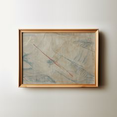 an abstract painting hangs on the wall above a wooden framed artwork piece in a wood frame