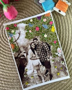 a couple is posing in front of some flowers and yarns on the ground with their handmade photo