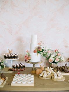 a table topped with lots of cakes and cupcakes