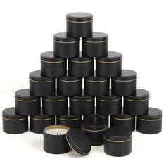 a pyramid made out of black containers and a candle