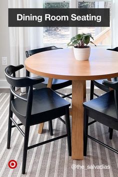 a dining room table with four chairs and a potted plant on the center piece