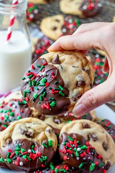 chocolate chip cookies with sprinkles are being held up by someone's hand