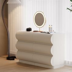 a white dresser with a mirror and other items on it