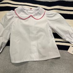 White Blouse With Pink Trim On Peter Pan Collar. Button Up Back With Button Cuffs. New With Tags Cute White Top With Peter Pan Collar, Cute White Top With Doll Collar, Cute Collared White Blouse, Cute White Collared Blouse, White Cotton Doll Collar Shirt, Cute Long Sleeve Blouse For School, White Cotton Shirt With Doll Collar, White Long Sleeve Blouse For School, White School Blouse For Spring