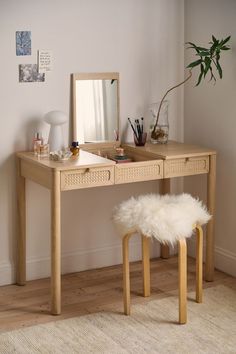 a wooden desk with a mirror and stool