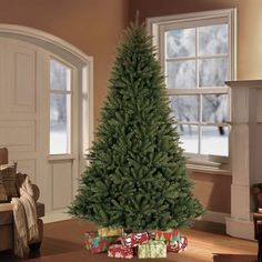 a christmas tree in a living room decorated for the holiday season with lights and presents