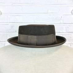 "Size 6 7/8 Vintage 1950s 1960s Adam Hats Carbon Brown Porkpie Fedora Hat For your consideration we have a vintage fedora from the '50s/'60s. Made by Adam Hats from a \"carbon brown\" fur felt, this \"Rugby\" model features a telescopic crown, brown grosgrain band and edge, leather sweatband, and rayon lining. There are a few spots on the hat band and a few stitches have come out of the leather sweatband. This is still a great hat and wonderful for anyone into slick bop midcentury style. Measure Midcentury Style, Denim Workwear, Green Cap, Model Features, Brown Fur, Hat Band, Philadelphia Pa, Fedora Hat, Hat Sizes