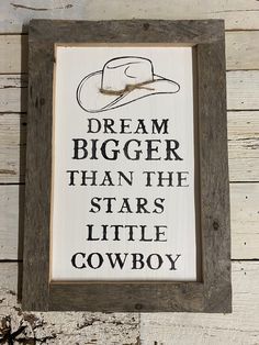 a wooden sign that reads, dream bigger than the stars little cowboy on white wood planks