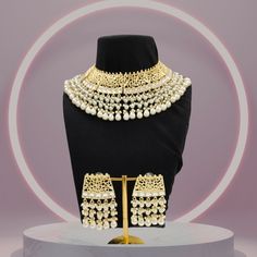 Product: Crafted with intricate Kundan work and adorned with lustrous pearls, this short kundan choker necklace sits snugly around your neck, exuding a luxurious appearance plated with high-quality gold. The addition of pearls imparts an aura of elegance and sophistication, making it a coveted choice for weddings, festivals, and special occasions.  Size & Material: Necklace Length: 7 cm Width: 22 cm Wt. : 94 gm Materials: Brass, 18K Gold Plated Closure: Fancy Dori Earring Length: 7 cm Width: 7 cm Wt. : 27 gm Materials: Brass, 18K Gold Plated Closure: Push back Occasions: Perfect for formal occasions like weddings or religious ceremonies, our choker necklace also complements everyday wear, elevating any outfit with its elegance and sophistication. Whether paired with traditional Indian atti Luxury Gold Plated Kundan Necklace For Festivals, Gold Kundan Necklace, Jewelry Pearl Necklace, Kundan Choker Necklace, Kundan Work, Wedding Necklace Set, Kundan Necklace Set, Kundan Choker, Kundan Necklace