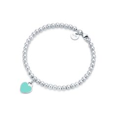 Inspired by the iconic key ring first introduced in 1969, the Return to Tiffany collection is a classic reinvented. An elegant bead bracelet and engraved tag combine to create a simple and timeless design. Sterling silver with Tiffany Blue® enamel finish; Size extra small; Fits wrists up to 5.25"; Beads, 4 mm; Instantly recognizable, the signature Tiffany Blue® hue of this design’s enamel finish has been as iconic as the brand itself since its founding in 1837 | Return to Tiffany® Tiffany Blue® Tiffany Bead Bracelet, Tiffany And Co Bracelet, Tiffany Bracelets, Return To Tiffany, Heart Tag, Turquoise Heart, Silver Bead Bracelet, Tiffany And Co, Heart Beads