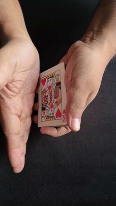 two hands holding playing cards in front of each other