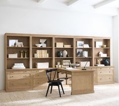 a desk with chairs and bookshelves in front of it on carpeted floor