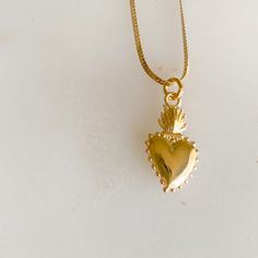 Sacred heart gold charm necklace. Sacred heart charm is 14K gold plate over sterling silver. The symbol represents boundless and passionate love for all of humanity. The flame or light surrounding the heart, signifies the divine light of love. It also symbolizes love for one another. Charm measures about 3/4”. Stamped 925. Hangs on 14K Gold filled (14KTGF) herringbone chain. Measures 18”. BelleStyle logo tag at clasp. Comes in a box inside a linen travel pouch. Made in USA. Waterproof. Symbolic Yellow Gold Heart Jewelry, Symbolic Gold Jewelry For Valentine's Day, Symbolic Necklace With Heart Charm For Anniversary, Symbolic Heart Charm Necklace For Anniversary, Gold Spiritual Heart Necklace, Gold Heart-shaped Spiritual Necklace, Spiritual Gold Heart Necklace, Symbolic Gold Jewelry With Heart Charm, Spiritual Yellow Gold Charm Necklace For Her