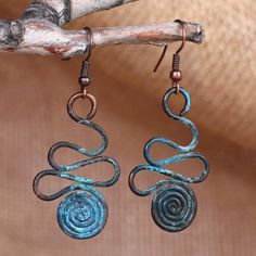 These unique dangle earrings feature copper wires that undergo a meticulous oxidation process, giving them their splendid aqua hue. Expertly handcrafted by artisan Arman Badeyan, they showcase a stunning spiral and swirl design complemented by brass hooks. Inspired by the vibrant artistry of Armenian culture, these accessories are a must-have for those who appreciate exquisite craftsmanship and distinctive style. Bohemian Spiral Copper Earrings, Bohemian Copper Spiral Earrings, Bohemian Spiral Copper Wire Earrings, Unusual Earrings Unique, Calder Jewelry, Wrapping Crystals, Wig Jig, Copper Wire Crafts, Unique Dangle Earrings