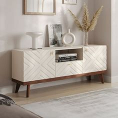 a living room with a white and brown cabinet next to a mirror on the wall