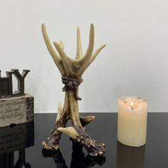 a candle is sitting on a table next to an antler