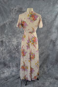 1970's Ivory and Pastel Colored Floral Print Maxi Dress and Matching Bolero A-line dress features spaghetti straps with an empire waist. Print is of bouquets of pastel colors in purple, red, blue, and yellow flowers. A zipper up the back and the halter top has buttons on the back. The matching bolero has a cap sleeve, the bolero ties under the bust. Label: Unknown - No Tag Present Measurements are taken flat; Dress Neck: 12 inches Bust: 13 inches Waist: 14 inches Hips: 18 1/2 inches Length (Top Vintage Flowy Dresses For Daywear, Flowy Vintage Dresses For Daywear, Retro A-line Cream Dress, Vintage White Maxi Dress With Short Sleeves, Vintage Beige Spring Dress, White Vintage Maxi Dress With Short Sleeves, Vintage Beige Dresses For Spring, Cream Dresses With Bias Cut For Vintage Events, Beige Vintage Spring Dress