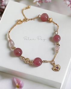 This bracelet featuring the enchanting hues of Strawberry Quartz, delicately adorned with a heart charm and set upon a gold color chain. This bracelet not only showcases the beauty of the crystal but also adds a touch of romance to your wrist.  Strawberry Quartz is often associated with love and emotional balance. It is believed to stimulate and amplify the energy of love, promoting feelings of compassion and understanding. Besides, Strawberry Quartz also have calming and soothing effect on the mind and emotions. It may help alleviate stress, anxiety, and tension, promoting a sense of inner peace. **Product name** Pink Crystal Bracelet - Strawberry Quartz Heart Charm Gold Color Chain Bracelet **Size** Unfolded: 23 cm long  Folded: Can be clipped on different buckles - 8.5 cm/ 10.5 cm / 11. Feminine Gold Bracelets For Valentine's Day, Elegant Gold Crystal Bracelet With Heart Charm, Valentine's Day Gold Crystal Bracelet With Heart Charm, Pink Crystal Bracelet, Rose Bracelet, Beads Bracelet Design, Strawberry Quartz, Les Sentiments, Pink Crystal