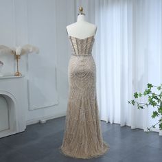 a dress on display in front of a white wall and window with curtains behind it