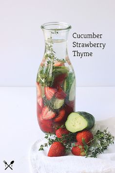 cucumber, strawberry and thyme in a glass jar on a white towel