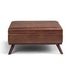 a brown leather ottoman sitting on top of a wooden table