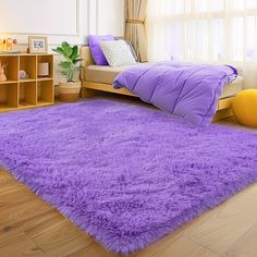 a purple rug is in the middle of a room with a bed and bookcases