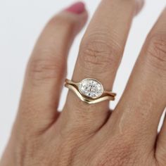 a woman's hand with a diamond ring on it