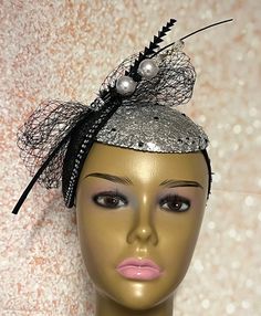 Looking for a head-turner? Look no further. This black and silver piece fits the criteria. Silver mesh fabric on sinamay base then trimmed with rhinestones and a hat pin. The hat pin may vary. Perfect for church and any other special occasions: tea parties, weddings, etc. Simple, yet chic. Length: approximately 9 inches Width: 5.5 inches (at the widest part) The hat pin may vary and is for decorative purposes only. The hat affixes to the head via a hat string. Handmade Gifts for mom, sister, wife, or yourself. PLEASE NOTE All items for Free Shipping will be shipped via USPS First Class Mail. Black Gatsby Style Fascinator For Evening, Black Gatsby Fascinator For Evening, Gatsby Style Black Fascinator For Parties, Black Gatsby Style Fascinator For Party, Black Gatsby Fascinator For Parties, Black Gatsby Style Party Fascinator, Black Headband Fascinator For Party, Black Gatsby Style Wedding Headpiece, Silver Headband For Evening