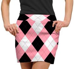 a woman wearing a pink and black argyle print skirt with her hands on her hips