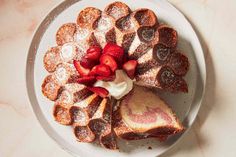 a white plate topped with waffles covered in powdered sugar and strawberries