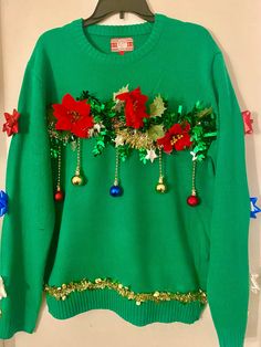 a green sweater with poinsettis and bells on it