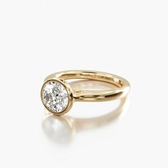 a yellow gold ring with a single diamond in the center, on a white background